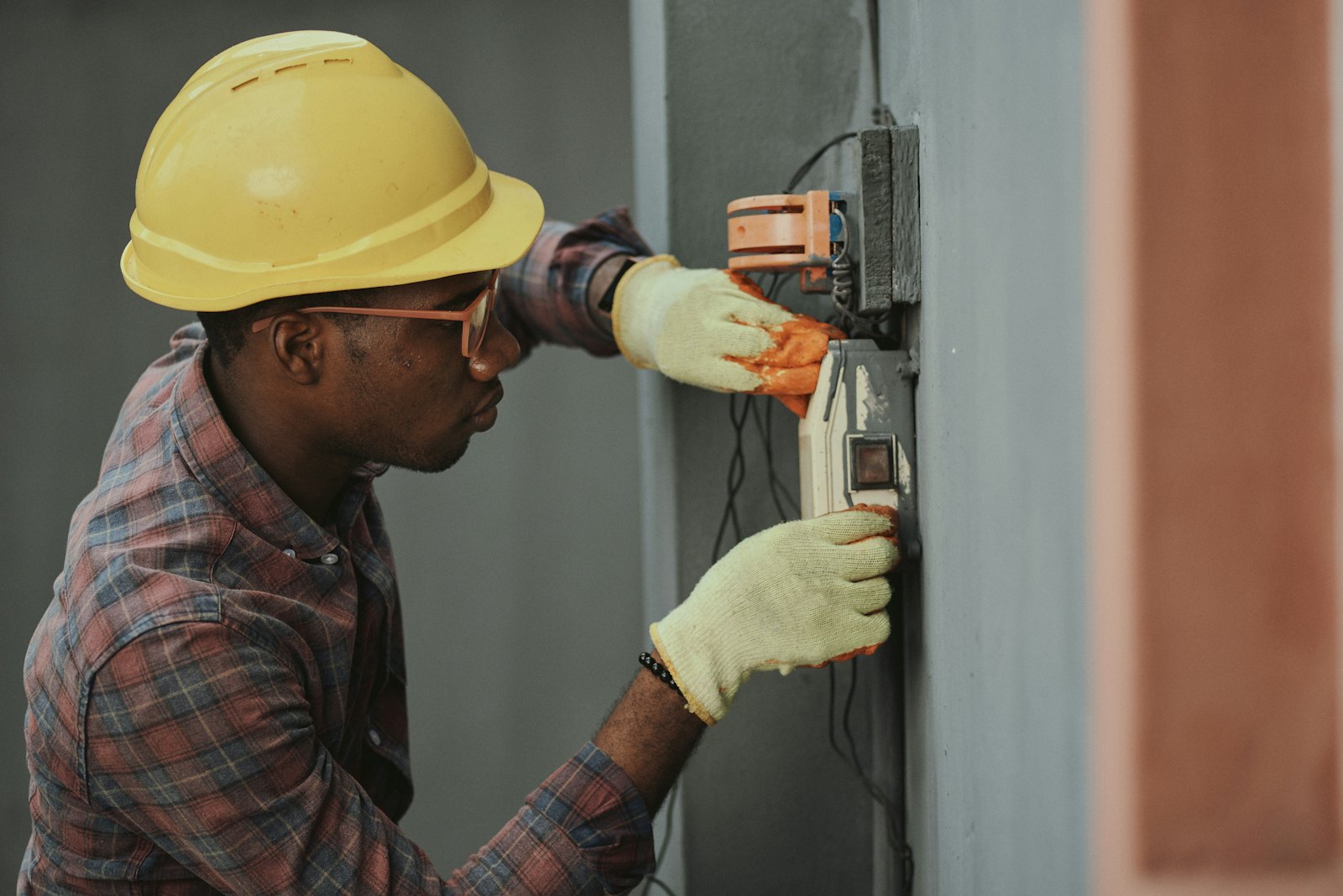 Electricista con casco amarillo revisando una instalación